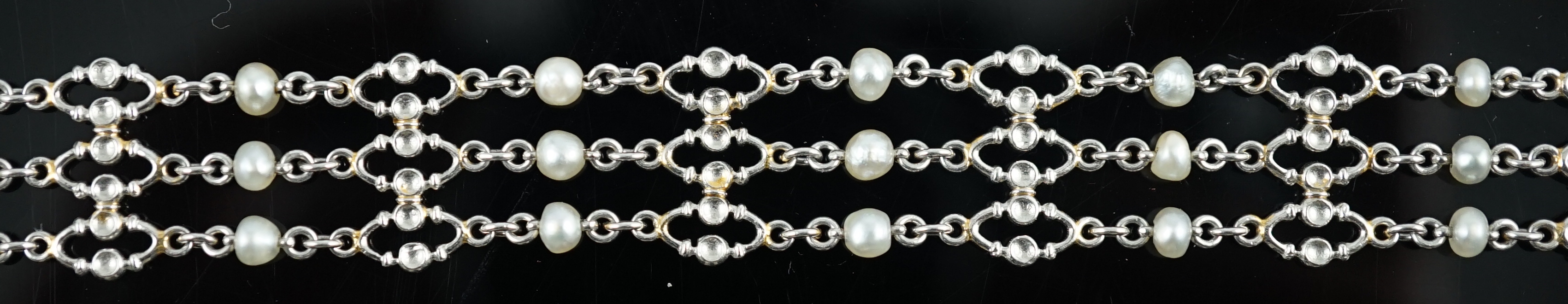 An early to mid 20th century white gold and seed pearl set three row chain link bracelet